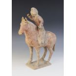 A Chinese pottery model of a polo player on horseback, possibly Han dynasty, the horse raised on