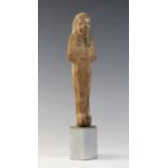 An Egyptian wood shabti, schematically carved with traces of the original pigment remaining, New