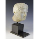 A carved marble male head, in the Roman manner, with curling hair and well defined features, un-