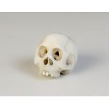 * A 19th century carved ivory Memento Mori carving modelled as a skull, 2.5cm high