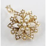 An Edwardian pearl set pendant brooch, designed as a central six-petal flower set to a