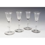 Four bell bowl wine glasses, each on a single series multi-spiral opaque twist stem with annular