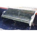 A 19th century cast iron and slatted garden bench, with three cast supports, the swept foliate