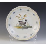 A faience tin glazed earthenware dish, decorated in the manner of Bristol with a goat in a