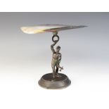 A figural bronze patinated mother of pearl mounted tazza, modelled as a tribal figure holding an