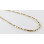 A gold coloured chain, comprising alternating curb links an plain polished links, lobster claw and