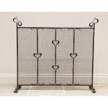 A blacksmith made wrought iron spark guard, in the Arts and Crafts style, of country house