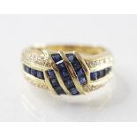 A diamond and sapphire twist design ring, set with square cut blue sapphires and mixed cut diamonds,