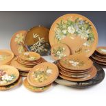 A collection of hand painted Watcombe pottery chargers and wall plaques, decorated with a hand
