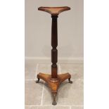 A 19th century mahogany torchere, the triform top with a raised moulded rim upon a wrythen an reeded