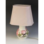A Moorcroft table lamp, of baluster form, decorated in the pink magnolia pattern against a cream