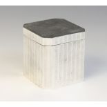 An Art Deco tea caddy, of faceted form with engine turned decoration, opening to reveal integral