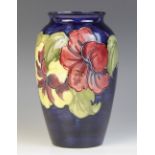 A Moorcroft 'Hibiscus' pattern vase, mid-20th Century, of tapering ovoid form with cobalt blue
