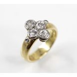 A diamond cluster ring, the central quatrefoil cluster comprising four round old cut diamonds,