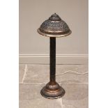 A Indian embossed copper floor standing lamp, the two-tiered dome base supporting a cylindrical