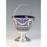 A George III silver swing handled sugar basket, Thomas Heming, London 1774, of tapering form with