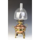 An Arts & Crafts brass and copper oil lamp, early 20th century, the circular copper reservoir set to