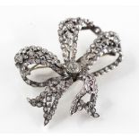 An early 19th century diamond set bow brooch, comprising a central old cut diamond measuring 4.5mm x