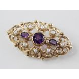 A Victorian style amethyst and simulated pearl 9ct gold brooch, designed as a central round mixed