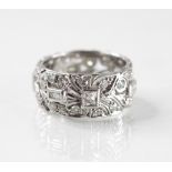 A diamond set ring, the pierced floral design band set with baguette cut, single cut and mixed