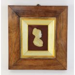 A wax silhouette, 19th century, modelled as a lady in a bonnet facing sinister, in rosewood frame,