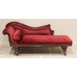 A late Victorian walnut framed chaise lounge, the shaped back carved with scrolled terminals