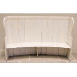 A 19th century painted pine curved back tavern settle, the bowed plank back extending to scroll