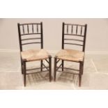 A pair of Arts and Crafts Morris type Sussex chairs, with a spindle and rail backs