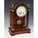 A late 19th century French mahogany and gilt metal mounted portico clock, the arched pediment