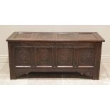 A large 18th century carved oak coffer, with a four panel hinged cover, the two central panels