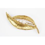 A 1960's 9ct gold cultured pearl set brooch, of abstract form with textured detail, four round