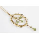 An Edwardian peridot and pearl 9ct pendant, the principal three branch drop set with round mixed cut