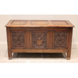 A 17th century style oak coffer, mid 20th century, the three panel hinged top over a central panel