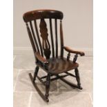 A stained beech wood rocking chair, 20th century, with a lath back and pierced central splat, the