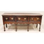 An early 18th century oak dresser base, the three plank moulded top above three lip moulded frieze