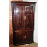 A George III oak and mahogany cross banded freestanding corner cupboard, the moulded cornice above a