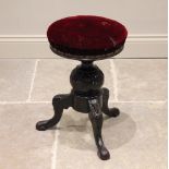 A Victorian carved and stained hardwood adjustable piano stool, the revolving red velour circular