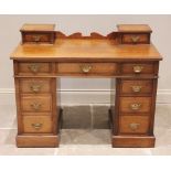 A late Victorian walnut twin pedestal dressing table/desk, the shaped rear gallery flanked by two