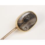 A 19th century carved hardstone cameo set stick pin, the oval shaped cameo carved with the profile