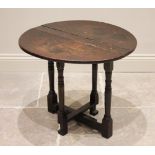 An 18th century and later narrow oak drop leaf occasional table, the circular top raised upon ring