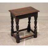 A 17th century and later oak joint stool, the rectangular moulded top raised upon baluster turned
