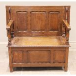 An early 20th century medium oak monks bench, the three panel sliding back rest raised upon four