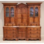 A mid 19th century inverted breakfront oak housekeepers cupboard, the central architectural pediment