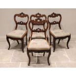 A set of four Victorian walnut dining chairs, each with a leafy crest over a 'C' scroll framed