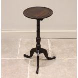 A George III oak tripod table or candle stand, the circular top with a raised moulded rim, upon a