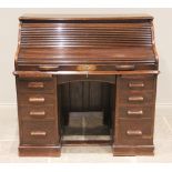 An early 20th century oak roll top desk, the tambour front opening to an arrangement of small