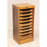 An early 20th century tambour front oak filing cabinet, the tambour drop front opening to nine