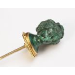 A malachite stick pin, carved in the classical style as a female head with waved hair and a crown of