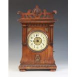A late 19th/early 20th walnut cased German musical bracket clock, the openwork pediment above an