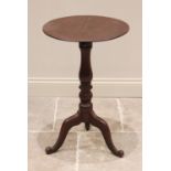 A Victorian mahogany adjustable tripod table, the circular top raised upon a baluster turned